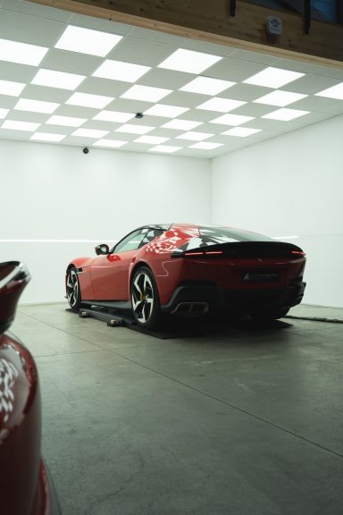 Ein roter Sportwagen steht in einem modernen, hellen Ausstellungsraum.